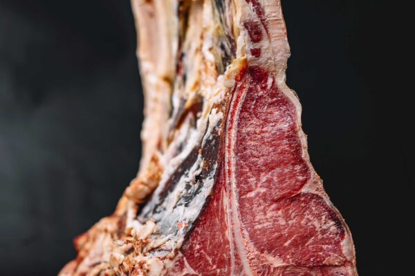 cerca-de-filete-de-ternera-crudo-t-bone-colocado-en-azul-marino